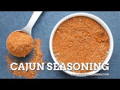 cajun seasoning in a white bowl next to a spoon with the words cajun seasoning on it