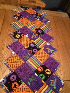 the table is covered with purple and orange quilted placemats that have pumpkins on them