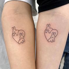 two people with matching tattoos on their legs, one has a heart and the other has rabbits