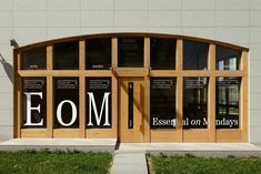 the front entrance to an empty building with wooden doors and letters on it's windows