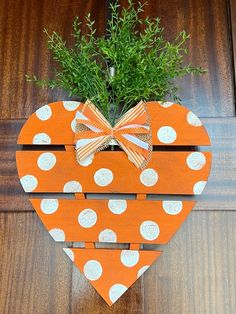 an orange heart shaped planter with white polka dots