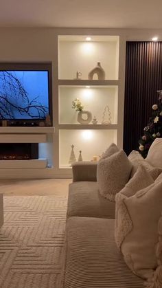 a living room filled with furniture and a flat screen tv mounted on a wall above a fireplace