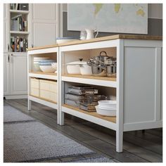 a kitchen with white cupboards and shelves filled with dishes on top of each shelf