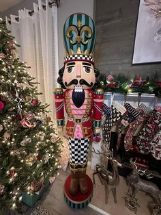 a large nutcracker standing next to a christmas tree