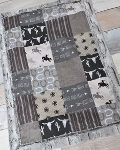 a close up of a patchwork quilt on a wooden floor with the words wild and free printed on it