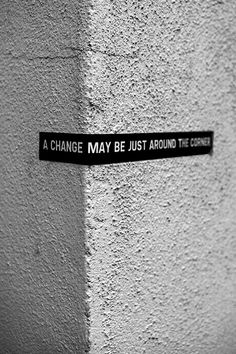 a black and white photo of a sign that says, a change may be just around the corner