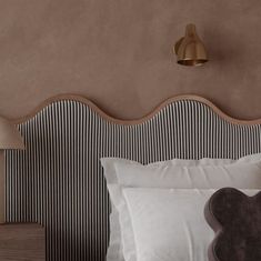 a bed with two pillows and a lamp on the headboard next to each other