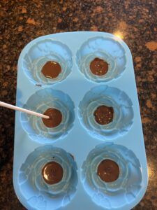 an ice tray with chocolates in it and a spoon sticking out of the top