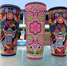 three decorated vases sitting on top of a table