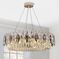 a chandelier hanging from the ceiling in a room with white walls and windows