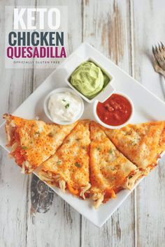 a white plate topped with quesadilla and sauces next to a fork