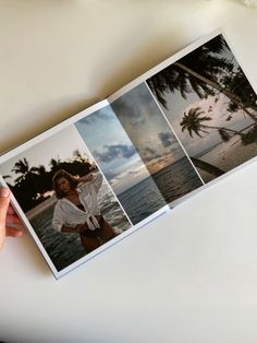 a person holding an open photo book with photos on it and palm trees in the background