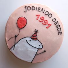 a pink birthday cake with an image of a hippo holding a balloon and the words jodiendo dedee on it