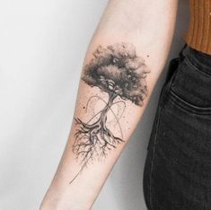 a woman's arm with a tree tattoo on it