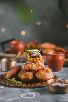 a plate full of food sitting on top of a table next to cups and saucers