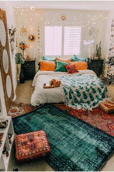 a bed room with a neatly made bed and lots of pillows on the floor next to a window