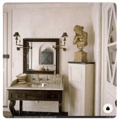 a bathroom sink sitting under a mirror next to a doorway