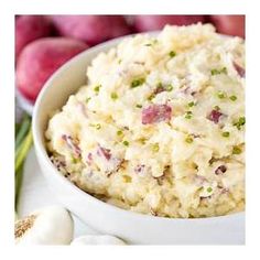 a bowl filled with mashed potatoes next to some vegetables