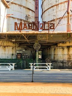 an old factory building with two large silos in the background