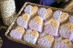 some heart shaped cookies are on a tray next to a gold sequin vase and other decorative items