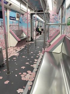 the interior of a subway car with pink flowers on the floor and silver railings