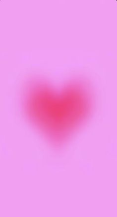 a blurry image of a red heart on a pink background