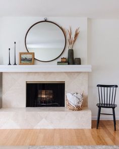 a living room with a fireplace and mirror above it