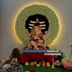 there is a statue of lord ganesh in the middle of a room with flowers and candles around it