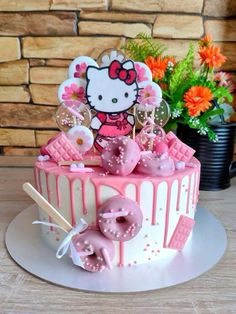 a hello kitty cake decorated with pink frosting and sprinkles