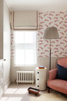 a living room with a red couch and white radiator next to a window