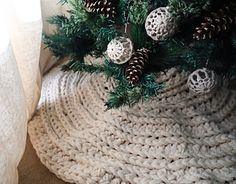 a crocheted christmas tree skirt with pine cones