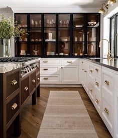 a kitchen filled with lots of white cabinets and counter top space next to a window