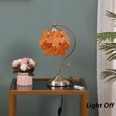 a table with a lamp on it next to a potted plant