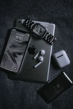 an iphone, watch and earbuds are laying on the floor next to each other