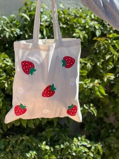 This strawberry tote bag with flowers is fun, lightweight, and is the perfect eco friendly reusable grocery tote bag. The strawberries add beautiful bright color, fun, and a cute aesthetic to go with your outfits. Use you tote bag in place of a purse, to carry your laptop, water bottle or other goodies.  This canvas tote is natural color and is 100% cotton.  Strawberry pattern may differ slightly as they are hand placed. CARE INSTRUCTIONS: Wash inside out on a gentle cycle. Hang dry. Iron inside out. Do not iron directly on top of the design.  Please message us with any questions.  Thank you! Painted Totes Ideas, Tote Bag Pattern Paint, Flower Tote Bag Painting, Cute Strawberry Print Tote Bag, Cute Spring Tote Bag, Tote Bag Design Ideas Paint, Summer Strawberry Print Bag For Daily Use, Summer Strawberry Print Bags For Daily Use, Cute Reusable Tote Bag