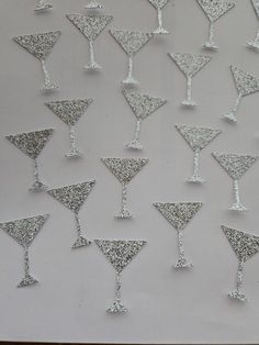 silver glittered martini glasses are arranged on a white background