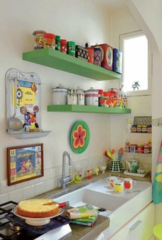 a kitchen filled with lots of shelves and dishes on top of the stovetop next to a sink