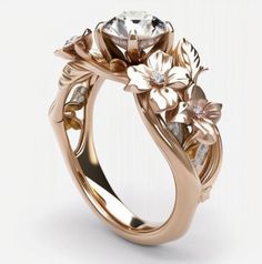 a gold ring with flowers and leaves on the side, set against a white background