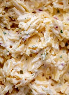 a close up view of macaroni salad with cheese and herbs on it,