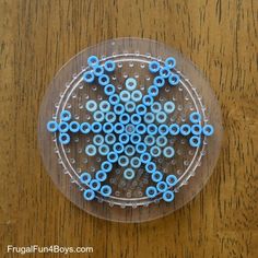 a plastic plate with some blue beads in it on a wooden table and brown surface