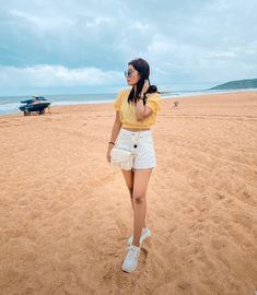 a woman standing on top of a sandy beach