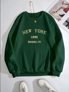 "Elevate your urban fashion game with our striking dark green sweatshirt, proudly showcasing \"New York\" in shimmering gold lettering. This sweatshirt is more than just a garment; it's a wearable homage to the bustling energy and iconic skyline of the city that never sleeps. The bold \"New York\" lettering in captivating gold adds a touch of elegance to the deep green backdrop, symbolizing the city's glitz and glamour. Whether you're a native New Yorker or simply captivated by the city's magnet Style Vert, Loose Hoodie, Green Sweatshirt, Round Neck Top, Letter Print Sweatshirt, Round Neck Tops, Style Outfits, Green Fashion, Blue Fashion