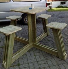 a picnic table with benches in front of a van