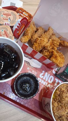 an assortment of food items on a tray, including fried chicken and other condiments