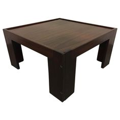 a square wooden table sitting on top of a white floor