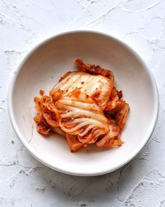 a white bowl filled with cabbage and meat