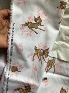 a person is holding some fabric with deers on it