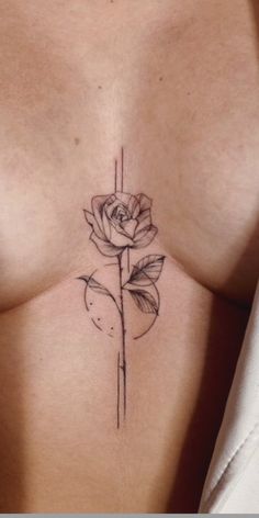 a woman's breast with a rose tattoo on her left side ribcage