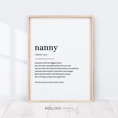 a framed poster with the words namny in black and white, on a wooden floor