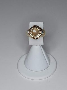 ITEM DESCRIPTION This is a vintage vermeil (gold over silver) ring.  It features a center glass moon glow cabochon.  On either side are cubic zirconia.  There are also cubic zirconia on the sides of the setting. See all photos please...they are part of the description. Markings/Stamps:  925 MEASUREMENTS: Size 7 Found in photos - please review all photos  **Due to age, there may be a small amount of age flaws not deemed to be worthy of noting...straw marks, bubbles, some scuffing, some particles. Heirloom Gold Opal Ring With Cabochon, Heirloom Gold Opal Cabochon Ring, Classic Gold Moonstone Cabochon Ring, Classic Cabochon Moonstone Ring, Classic Round Cabochon Moonstone Ring, Gold Moonstone Cabochon Ring, Fine Jewelry Gold Moonstone Ring, Gold Moonstone Round Ring Fine Jewelry, Gold Moonstone Ring In 14k Gold